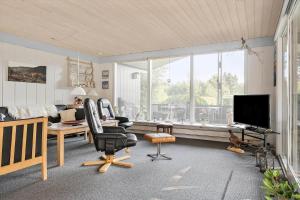 a living room with two chairs and a television at LF11351-Farso-Fjordparken-19 in Lovns