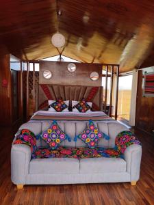 a couch sitting in front of a bed in a train at Brisas del Titicaca Perú in Puno