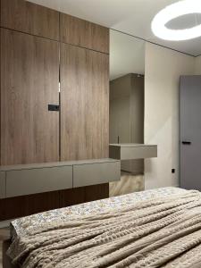 a bedroom with a bed with a large wooden cabinet at Апартаменты в центре Астаны in Astana +4 photos