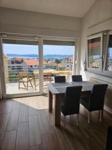 une salle à manger avec une table et des chaises et un balcon dans l'établissement Apartmani Lu, à Zadar