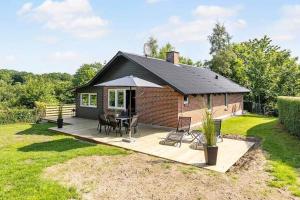 a house with a deck with a table and an umbrella at SB53786-Aabenraa-Kloften-3 in Brøde