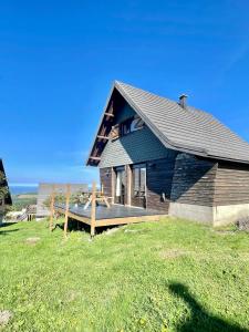 una casa sentada en la cima de un campo de hierba en La cabane au pied des pistes, en Chastreix