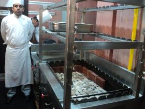 two men standing in a kitchen preparing food at Hotel BLUE DIAMOND in Jāmb