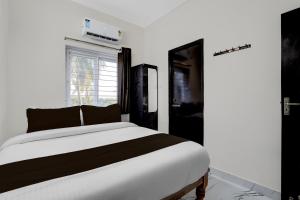 a bedroom with a white bed and a window at Hotel O ELITE STAY in Navalur