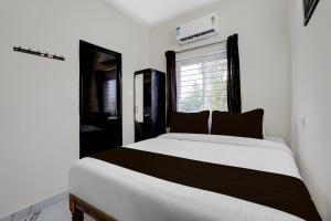 a bedroom with a white bed and a window at Hotel O ELITE STAY in Navalur