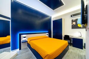 um quarto com uma cama azul e amarela e uma secretária em Guesthouse Pop em Roma