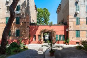 um edifício vermelho com uma arcada num pátio em Guesthouse Pop em Roma