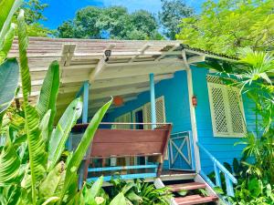 a blue house with a bench in front of it at Ita Ita Casitas Family Vacation Playa Punta Uva in Punta Uva
