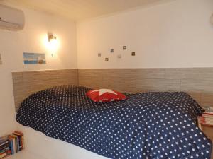 a bedroom with a blue and white bed with a red pillow at Drescher Apartments in Murter