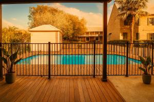 a balcony with a fence and a swimming pool at Campbelltown Colonial Motor Inn in Campbelltown
