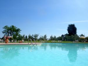 a large swimming pool with blue water in a park at Fattoria di Colleoli in Colleoli