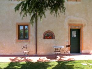 einen Tisch und Stühle vor einem Gebäude in der Unterkunft Fattoria di Colleoli in Colleoli