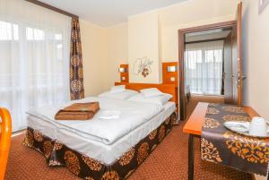 a hotel room with a bed and a table at Willa Saga in Władysławowo