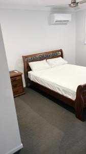 una camera con letto e comodino accanto a un letto sidx sidx. di Brassall Haven Retreat a Coalfalls