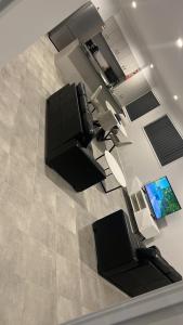 vista sul soffitto di un soggiorno con 2 sedie e una TV di Brassall Haven Retreat a Coalfalls