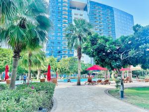 a park with palm trees and benches and buildings at Modern City Escape Gate Towers Al Reem in Abu Dhabi