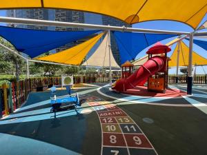 a playground with a red slide and a red slide at Modern City Escape Gate Towers Al Reem in Abu Dhabi