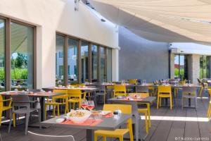 热纳帕尔凯斯特酒店的一间空餐厅,配有桌子和黄色椅子