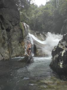 two people standing on a rock in a waterfall at Heeloya mount view garden in Teldeniya