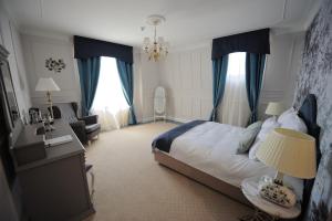 a bedroom with a large bed with blue curtains at Hotel Splendid 1900 in Craiova
