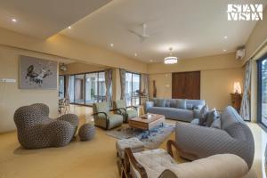 Un lugar para sentarse en StayVista at Villa Lemonade with BBQ & Bonfire