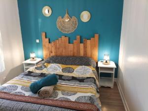 a bedroom with a bed with a wooden headboard and two tables at La plage et le calme in Marennes