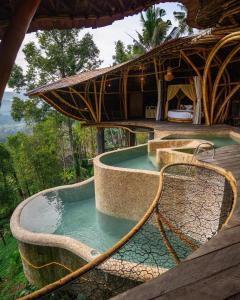 a pool of water in a resort with a building at Veluvana Mountain in Sidemen +55 photos