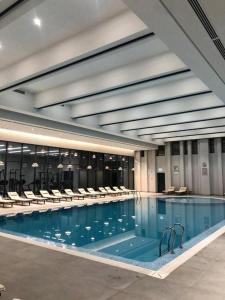 a large swimming pool with chairs in a building at Tashkent City Gardens Residence D11-4-27 in Tashkent