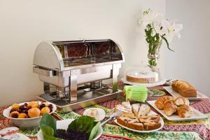uma mesa coberta com pão e pastelaria e uma batedeira em Pragatto Hills by Casino di Pragatto em Crespellano