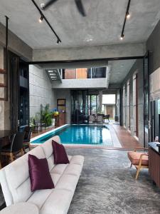 a living room with a couch and a swimming pool at Villa AZJA PD in Port Dickson