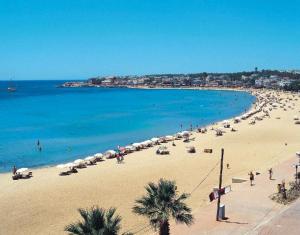 a beach with a bunch of umbrellas and the ocean at Baskent Otel in Didim