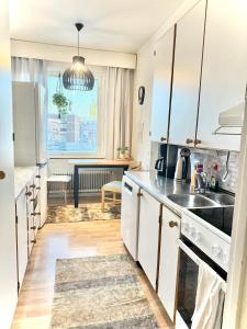a kitchen with white cabinets and a sink at Midnight Sun center apartments in Sodankylä