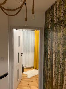 a room with a door and a window with yellow curtains at Domki nad stawem nr2 