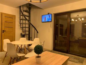 a living room with a table and chairs and a tv at Domki nad stawem nr2 in Majdan Nowy +11 photos