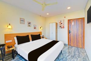 a bedroom with a large bed and a door at Super Townhouse CASA GRAND ECIL in Hyderabad