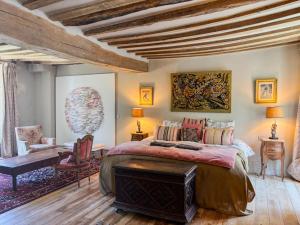 ein Schlafzimmer mit einem großen Bett und einem Tisch und Stühlen in der Unterkunft Le manoir de Saint-Ouen avec piscine chauffée intérieure in Saint-ouen-de-la-Cour + 42 Fotos