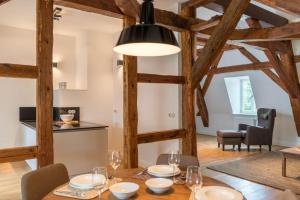 a dining room with a wooden table and a light fixture at Schloss Beuchow in Lübbenau