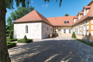 ein großes weißes Gebäude mit rotem Dach in der Unterkunft Schloss Beuchow in Lübbenau