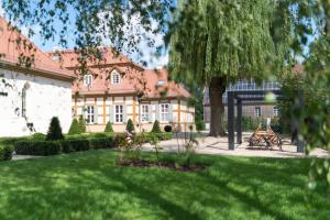 una casa grande con un césped verde delante de ella en Schloss Beuchow, en Lübbenau