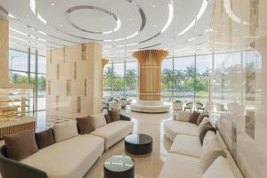 un grand hall avec des canapés, des tables et des fenêtres dans l'établissement Wyndham Soleil Danang - Free Two ways Airport Transport, à Đà Nẵng