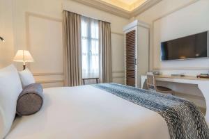 a hotel room with a large white bed and a desk at Hotel Caribe by Faranda Grand, a member of Radisson Individuals in Cartagena de Indias