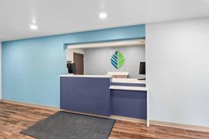 an office lobby with a blue wall at WoodSpring Suites Richmond Airport in Henrico