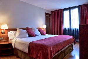 バルセロナにあるITC Barcelona By Soho Boutiqueのベッドルーム1室(赤いカーテン付きの大型ベッド1台付)