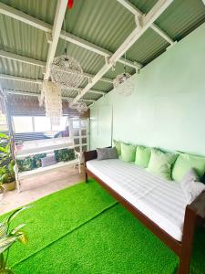 a living room with a bed with a green rug at BACKDOOR VILLA in Baler