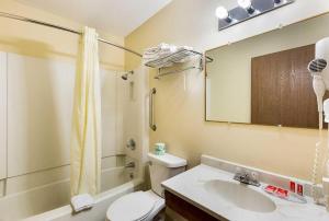Un baño con lavabo, inodoro y espejo. en Americas Best Value Inn Beatrice, en Beatrice 92 fotos más