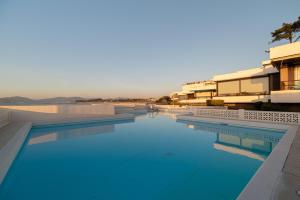 a swimming pool with blue water in a resort at Suite Deluxe Samil in Vilamar