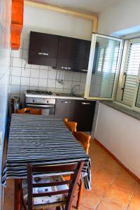 トロペアにあるCasa Vacanze Piaggioのキッチン(黒と白のテーブル、椅子付)