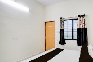 a bedroom with a bed and a window at SPOT ON Hotel Royal Inn in Chandrapur
