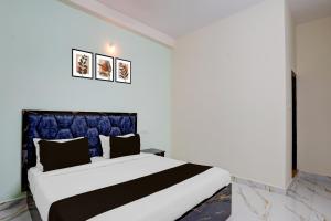 a bedroom with a large bed with a blue headboard at SPOT ON Hotel Royal Inn in Chandrapur
