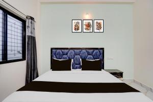 a bedroom with a large bed and a window at SPOT ON Hotel Royal Inn in Chandrapur
